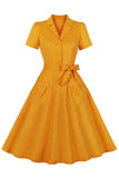 Vestido amarillo con volantes con muescas con solapa con lazos con cinturón de la década de 1950 con bolsillos