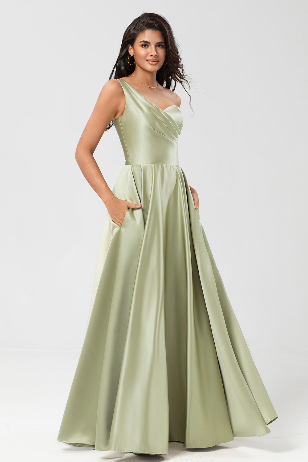 Un vestido de dama de honor verde satinado de hombro con bolsillos