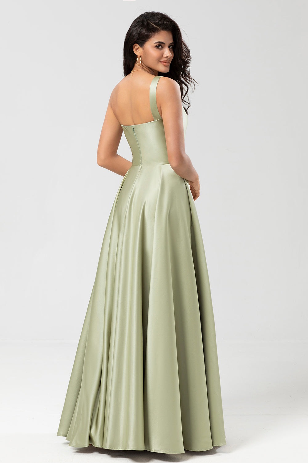 Un vestido de dama de honor verde satinado de hombro con bolsillos