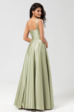 Un vestido de dama de honor verde satinado de hombro con bolsillos