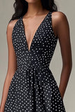 Vestido corto negro con escote en V y lunares blancos