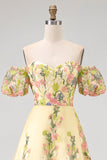 Vestido de invitad con alto y bajo con bordado floral amarillo y mangas abullonadas