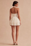 Un vestido mini corsé blanco con volantes con capas y halter, línea