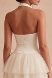 Un vestido mini corsé blanco con volantes con capas y halter, línea