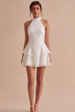 Un vestido mini blanco con volantes de escaleras con capas de lentejuelas y lentejuelas