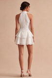 Un vestido mini blanco con volantes de escaleras con capas de lentejuelas y lentejuelas