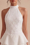 Un vestido mini blanco con volantes de escaleras con capas de lentejuelas y lentejuelas