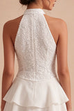Un vestido mini blanco con volantes de escaleras con capas de lentejuelas y lentejuelas